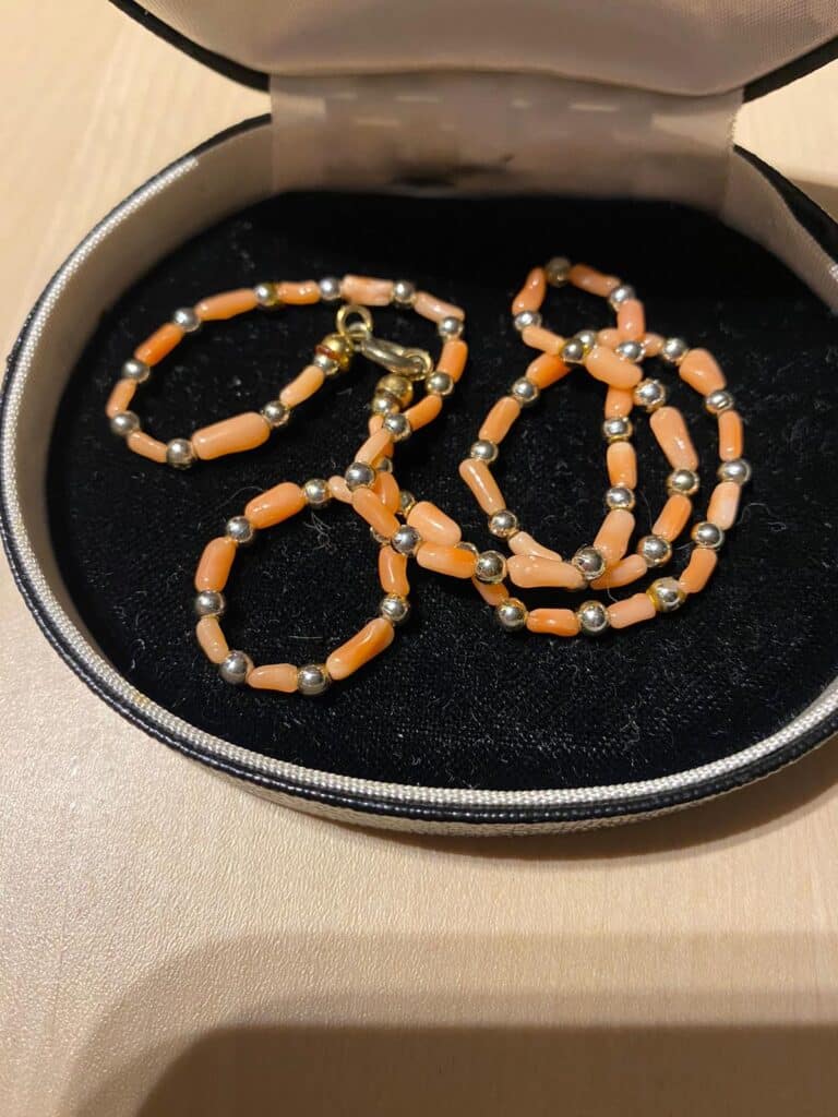 Halskette mit goldenen Perlen und orangen Steinen